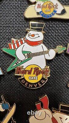 12 épingles Hard Rock Cafe Bonhommes de neige faisant du ski et du snowboard en jouant de la guitare en hiver